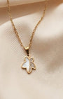 Gold necklace with a butterfly pendant on a beige fabric background
