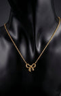 Gold necklace with a bow pendant on a black mannequin