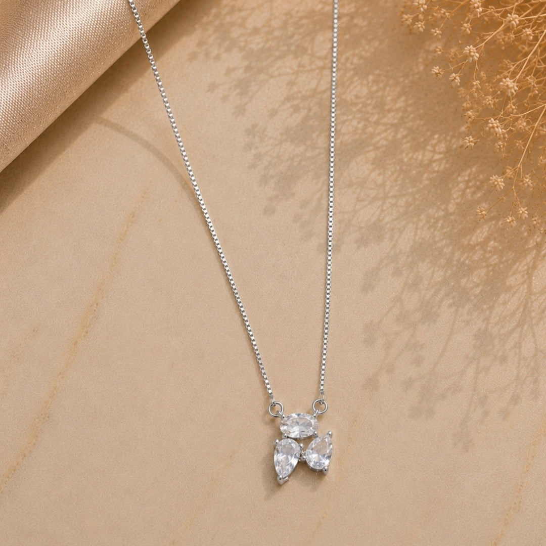 Silver 925 necklace with a leaf-shaped pendant on a beige fabric background